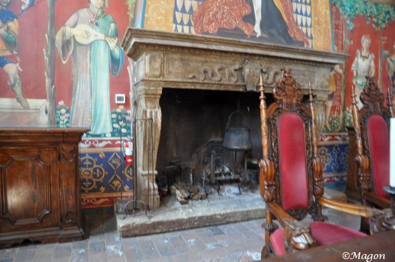 Castello Di Amorosa: камин с резными креслами и фресками в стиле средневековой Италии